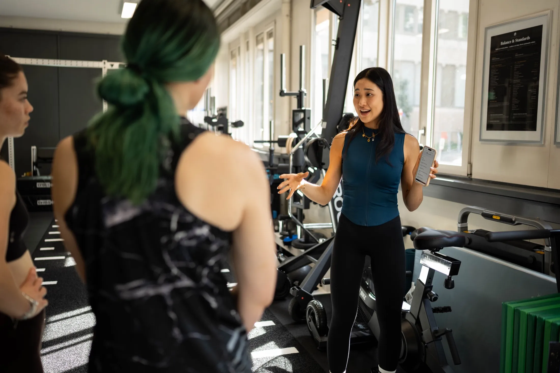 Coach Dahwi Lim erklärt Kundinnen im Trainingsstudio in Basel den Trainingsplan